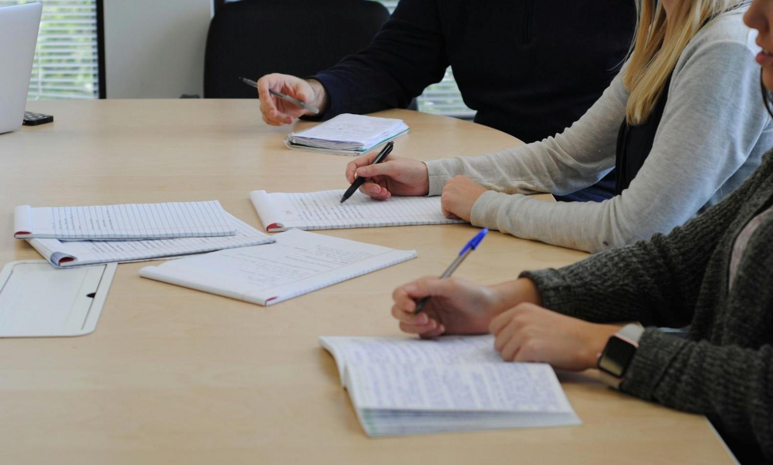 Team collaboration session with budget workflow diagrams on whiteboard